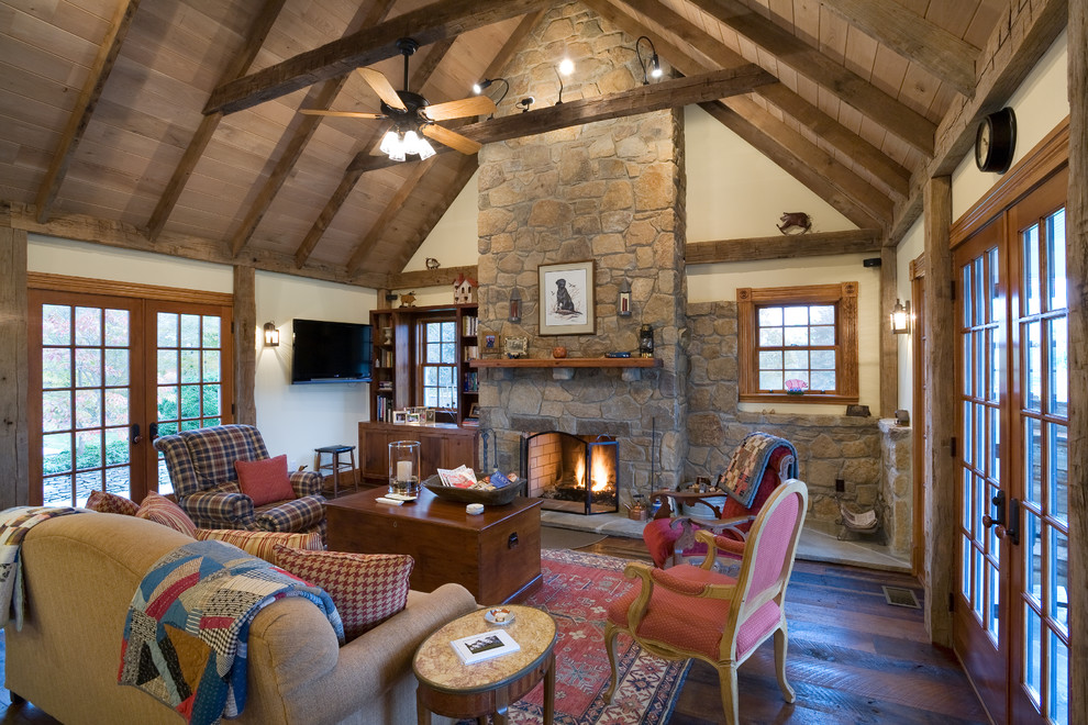Inspiration for a country open concept family room in DC Metro with beige walls, medium hardwood floors, a standard fireplace, a stone fireplace surround and a wall-mounted tv.