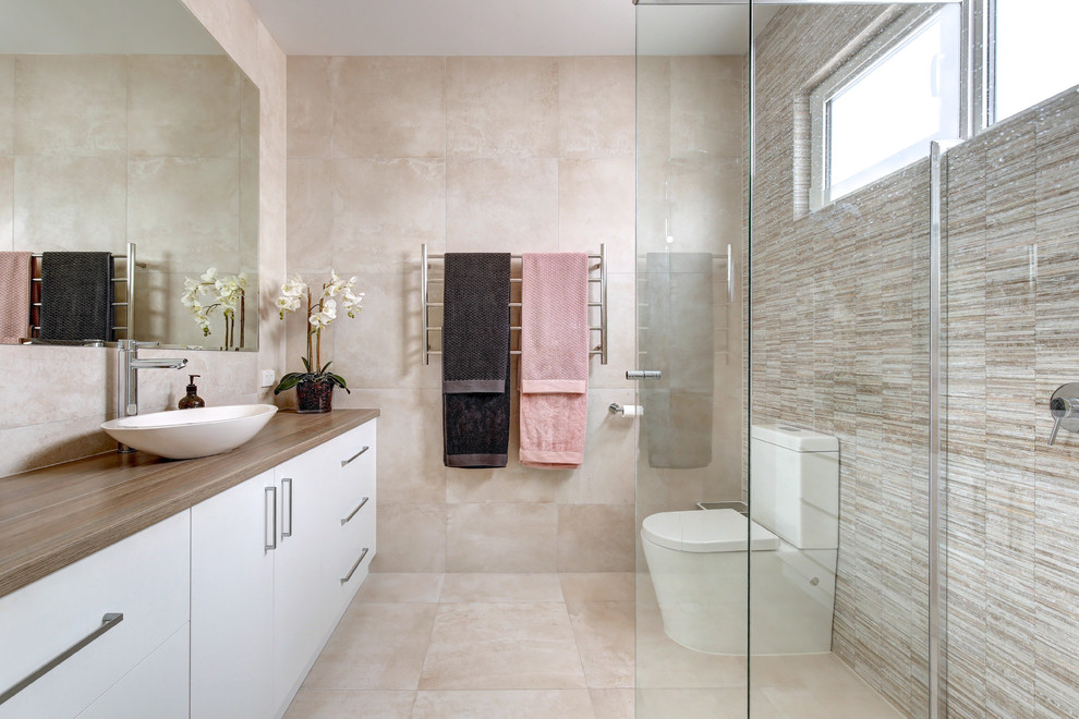 Design ideas for a mid-sized contemporary 3/4 bathroom in Adelaide with flat-panel cabinets, white cabinets, a corner shower, a one-piece toilet, beige tile, beige walls, a vessel sink, wood benchtops, beige floor and brown benchtops.