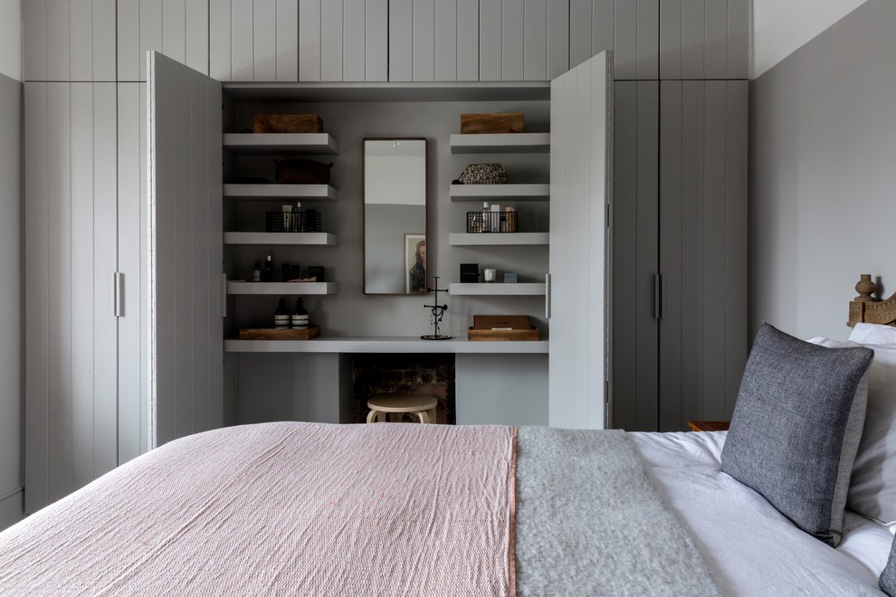 This is an example of a mid-sized transitional bedroom in London with grey walls.