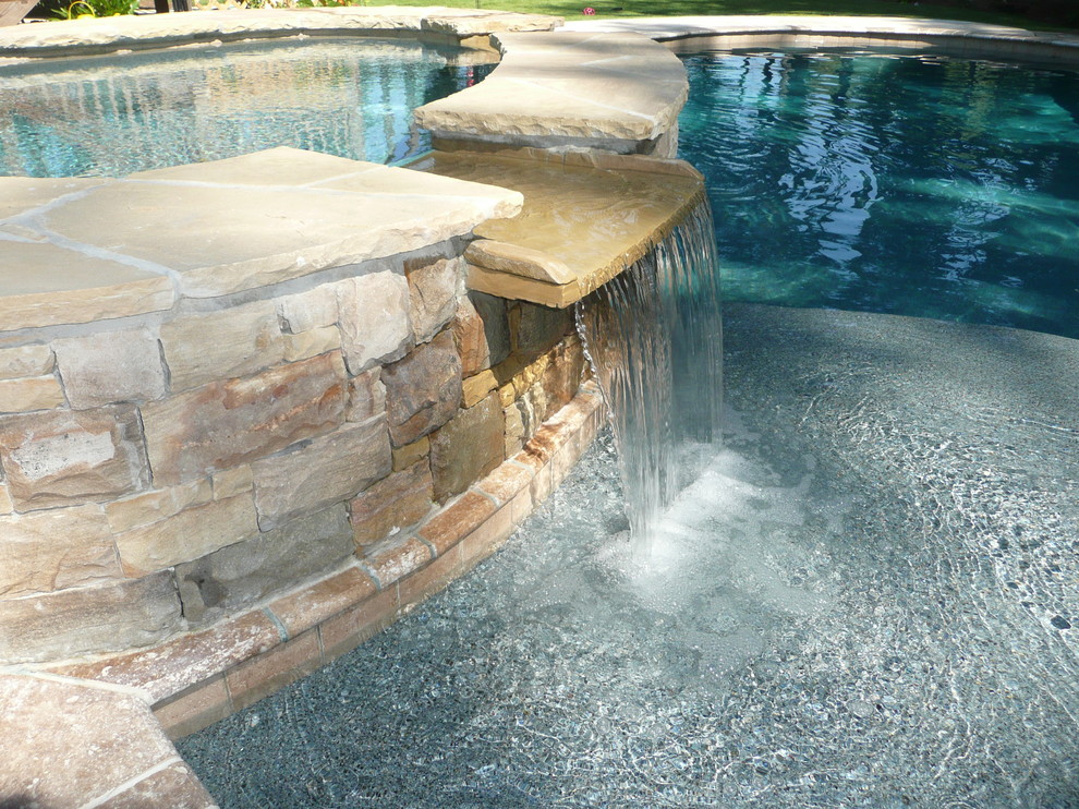 Pool fountain - mid-sized contemporary backyard stone and custom-shaped natural pool fountain idea
