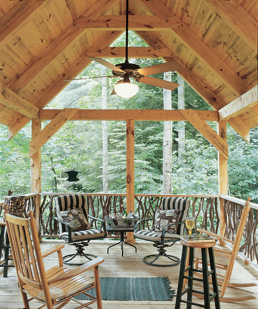 Inspiration for a mid-sized rustic backyard deck remodel in Other with a roof extension