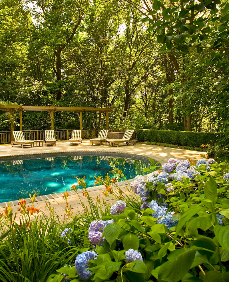 Photo of a mid-sized traditional round pool in New York with brick pavers.