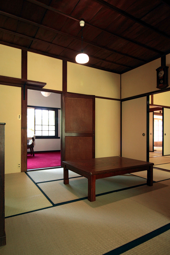 Photo of a mid-sized traditional dining room in Other with white walls, tatami floors, beige floor and wood.