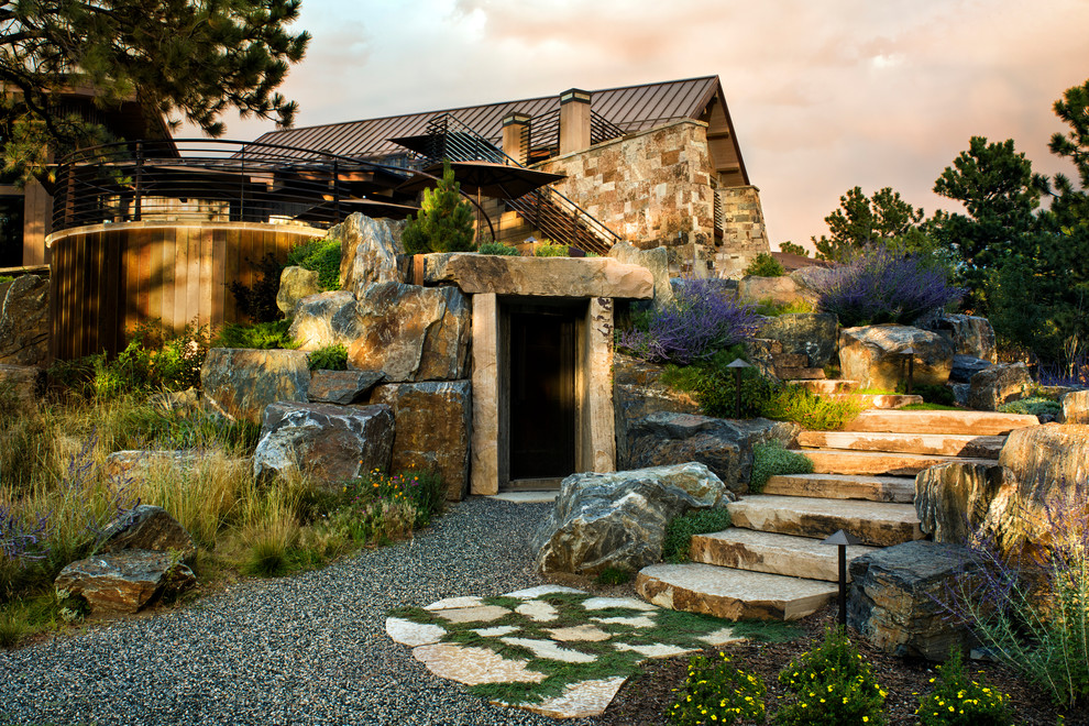 Design ideas for an expansive eclectic sloped xeriscape in Denver with natural stone pavers.