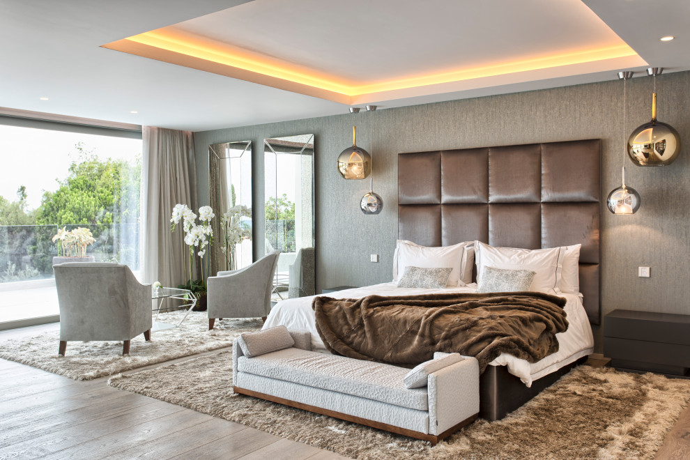 This is an example of a large contemporary master bedroom in Other with grey walls, light hardwood floors and beige floor.