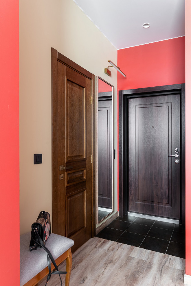 Идея дизайна: узкая прихожая среднего размера: освещение в стиле ретро с красными стенами, полом из винила, одностворчатой входной дверью, входной дверью из темного дерева, коричневым полом и обоями на стенах