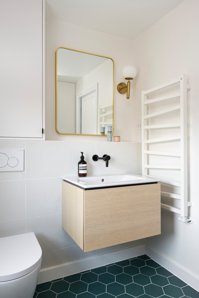 Small contemporary 3/4 bathroom in London with flat-panel cabinets, beige cabinets, an alcove shower, a one-piece toilet, green tile, green walls, ceramic floors, an integrated sink, green floor, a hinged shower door, white benchtops, a niche, a single vanity and a floating vanity.