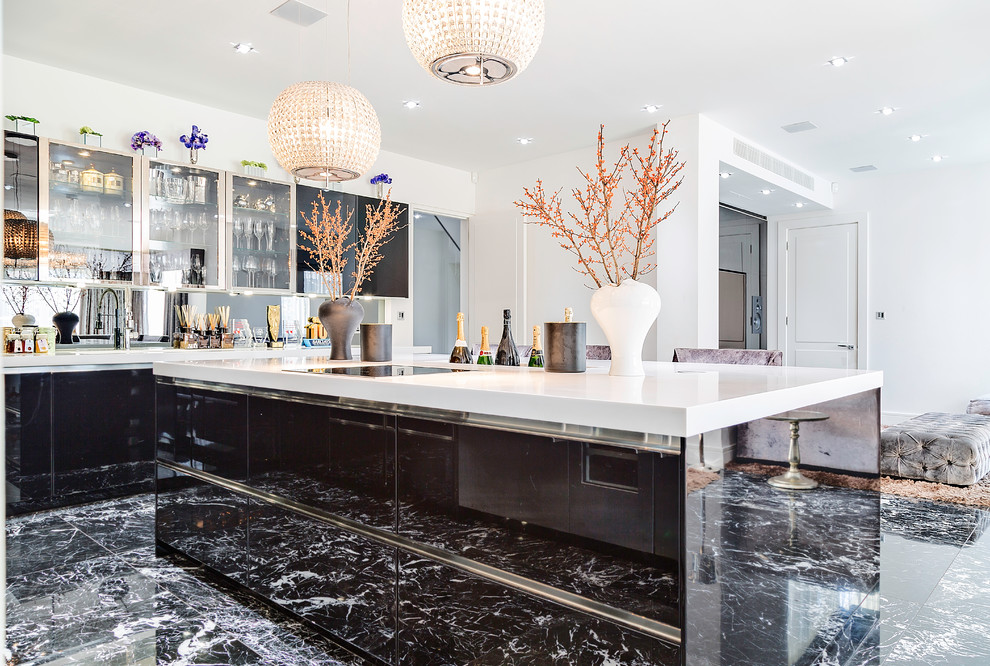 Photo of a large contemporary l-shaped open plan kitchen in London with flat-panel cabinets, black cabinets, mirror splashback, stainless steel appliances, with island, an undermount sink, solid surface benchtops, metallic splashback and marble floors.