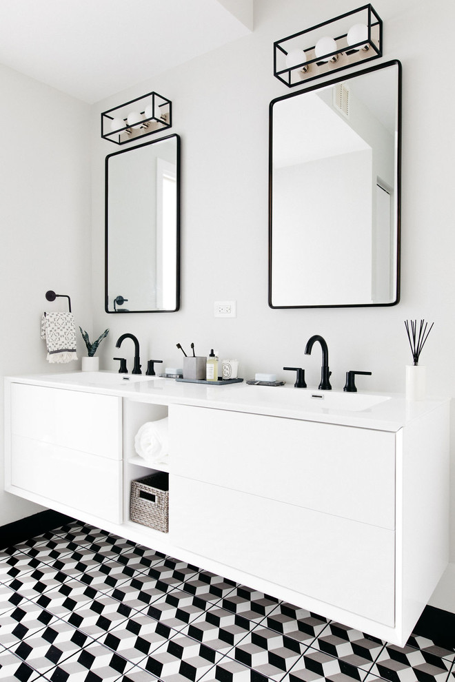 This is an example of a mid-sized contemporary master bathroom in Chicago with flat-panel cabinets, white cabinets, a drop-in tub, a two-piece toilet, white tile, subway tile, porcelain floors, an integrated sink, solid surface benchtops, black floor, white benchtops and white walls.