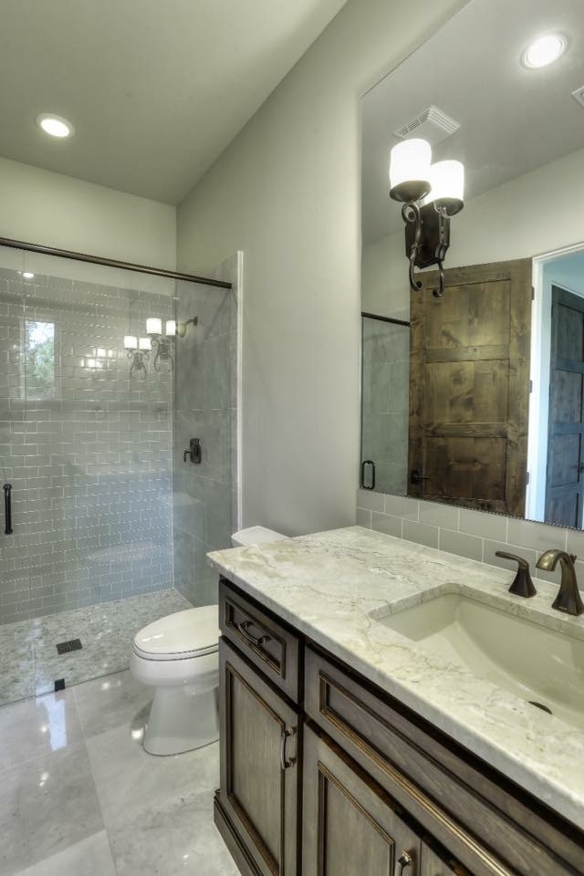 Alcove shower - mid-sized transitional 3/4 gray tile and subway tile marble floor alcove shower idea in Austin with recessed-panel cabinets, medium tone wood cabinets, a one-piece toilet, gray walls, an undermount sink and granite countertops