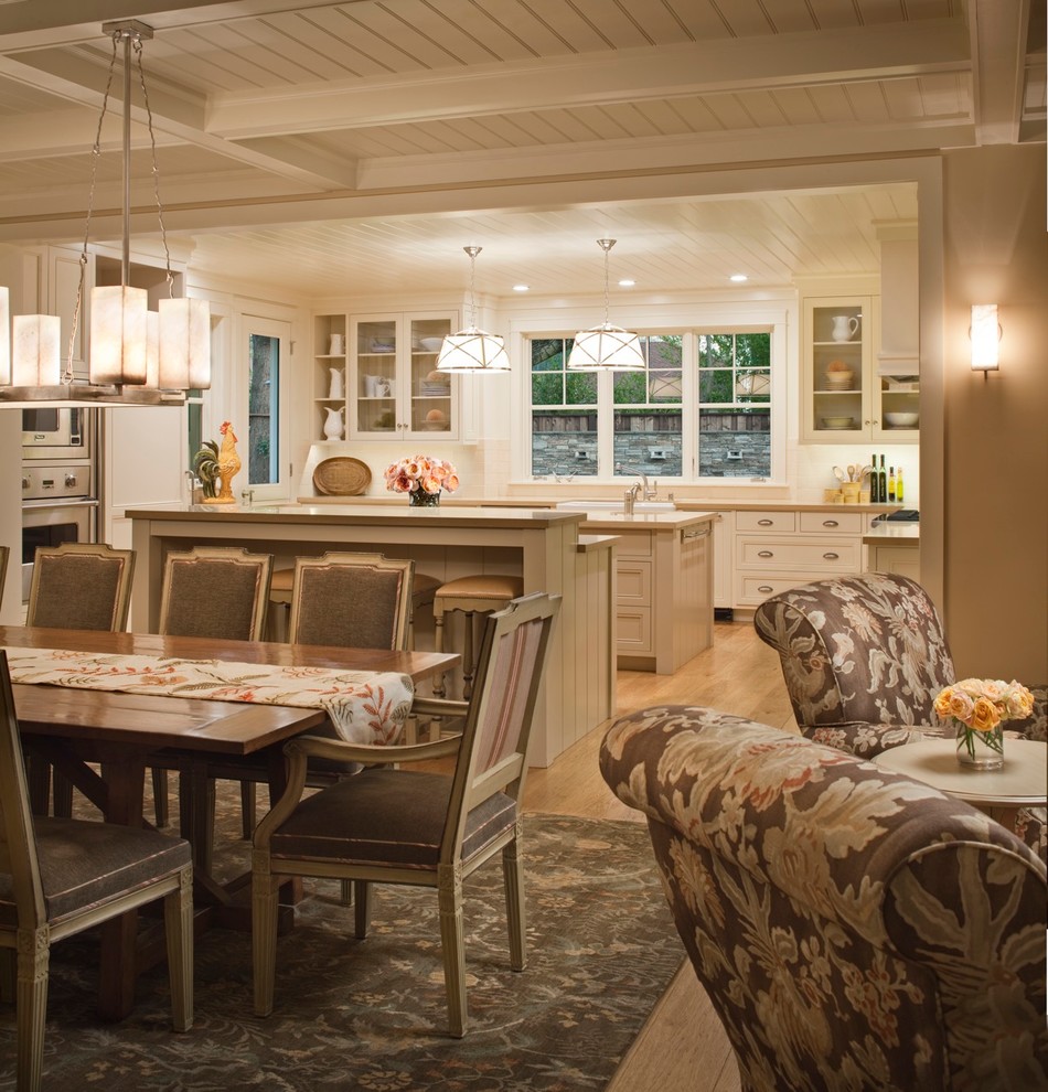 This is an example of a large country kitchen/dining combo in San Francisco with light hardwood floors, beige walls, no fireplace and brown floor.