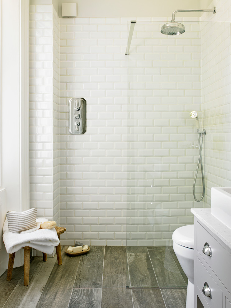 Transitional 3/4 white tile and subway tile corner shower photo in London with flat-panel cabinets and gray cabinets