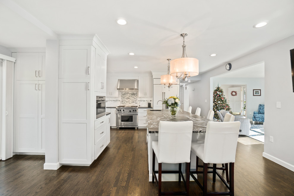 Inspiration for a huge transitional u-shaped dark wood floor and brown floor eat-in kitchen remodel in Providence with an undermount sink, recessed-panel cabinets, white cabinets, granite countertops, white backsplash, marble backsplash, stainless steel appliances and an island