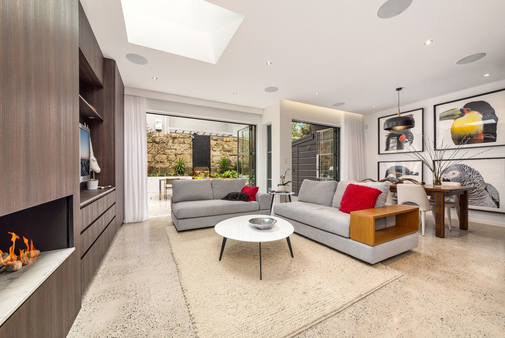 This is an example of a mid-sized contemporary open concept living room in Sydney with white walls, concrete floors, a ribbon fireplace and a built-in media wall.