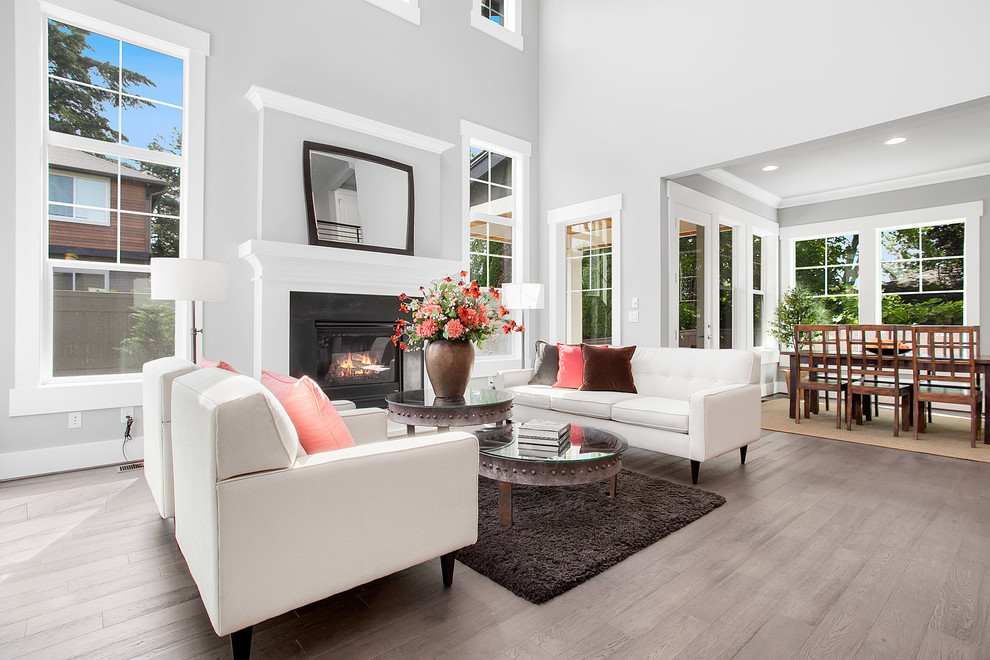This is an example of a large transitional open concept living room in Seattle with grey walls, medium hardwood floors, a standard fireplace and a tile fireplace surround.