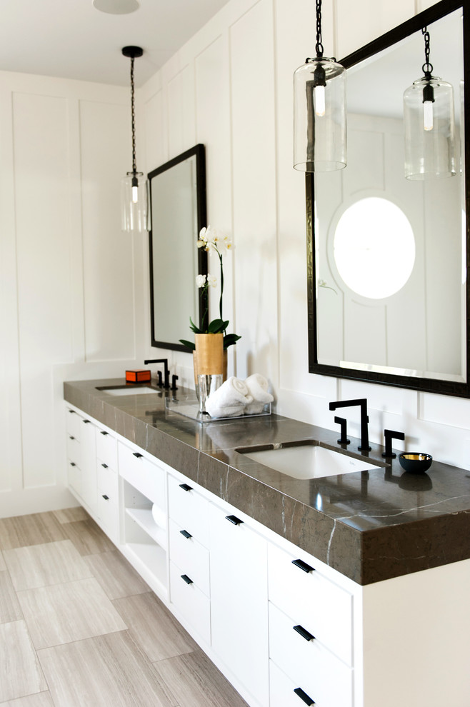 This is an example of a contemporary master bathroom in Orange County with flat-panel cabinets, white cabinets, a freestanding tub, gray tile, stone tile, white walls, marble floors, an undermount sink and marble benchtops.