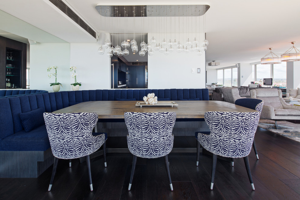 Large beach style open plan dining in Sydney with white walls, dark hardwood floors and black floor.
