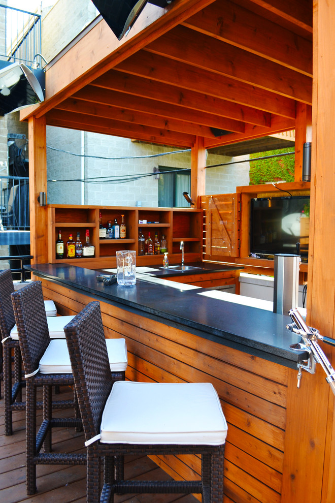 This is an example of a mid-sized transitional rooftop deck in Chicago with an outdoor kitchen and a roof extension.