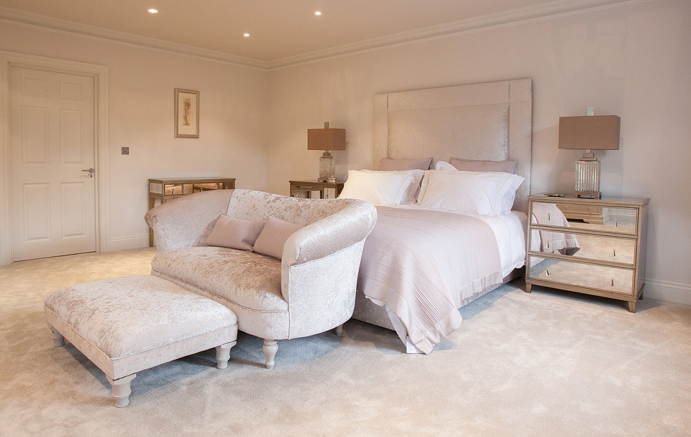 This is an example of a transitional master bedroom in Surrey with beige walls and carpet.