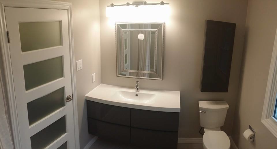 Contemporary 3/4 bathroom in Toronto with an integrated sink, flat-panel cabinets, dark wood cabinets, solid surface benchtops, a one-piece toilet and white walls.