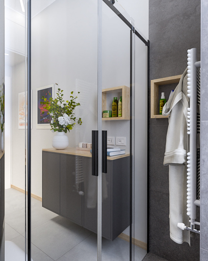 Industrial 3/4 bathroom in Milan with open cabinets, black cabinets, an alcove shower, a wall-mount toilet, white tile, subway tile, grey walls, porcelain floors, a vessel sink, wood benchtops, grey floor, a sliding shower screen, a laundry, a single vanity, a freestanding vanity and recessed.