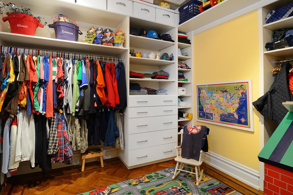 Inspiration for a huge timeless men's medium tone wood floor walk-in closet remodel in New York with flat-panel cabinets, white cabinets and yellow walls