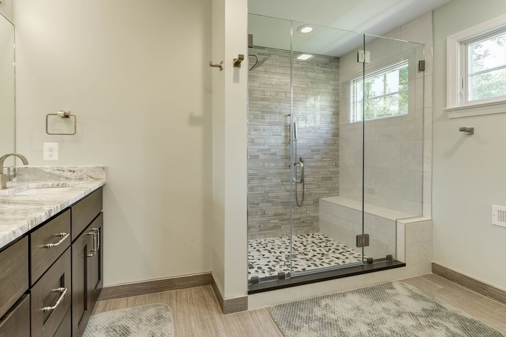 Inspiration for a large transitional master bathroom in DC Metro with shaker cabinets, dark wood cabinets, an alcove shower, beige tile, mosaic tile, beige walls, laminate floors, an undermount sink, engineered quartz benchtops, beige floor and a hinged shower door.