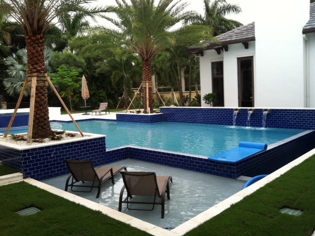 Large island style backyard custom-shaped natural pool fountain photo in Miami