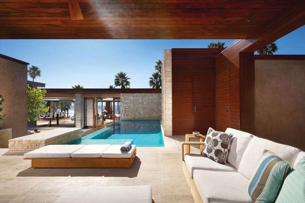 Inspiration for a mid-sized contemporary courtyard rectangular lap pool in Los Angeles with natural stone pavers.