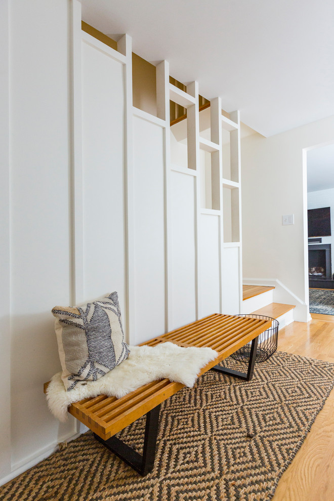 Inspiration for a modern hallway in Cincinnati with white walls, medium hardwood floors and brown floor.