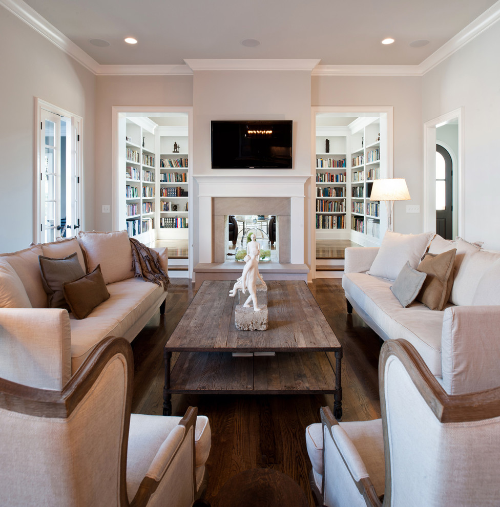 Inspiration for a traditional living room in Nashville with a two-sided fireplace, a library and dark hardwood floors.