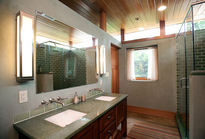Photo of a mid-sized asian 3/4 bathroom in DC Metro with recessed-panel cabinets, medium wood cabinets, a corner shower, green tile, subway tile, grey walls, concrete floors, an undermount sink, recycled glass benchtops and green benchtops.