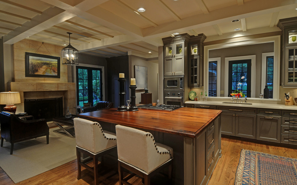 This is an example of a contemporary kitchen in Atlanta with glass-front cabinets, wood benchtops and grey cabinets.