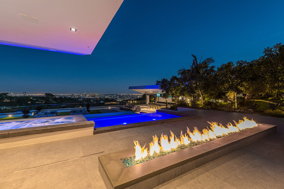 Expansive modern rooftop infinity pool in Los Angeles with a pool house.