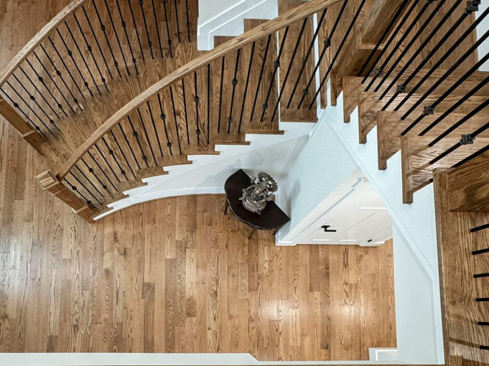 Foto de escalera curva clásica renovada de tamaño medio con escalones de madera, contrahuellas de madera y barandilla de varios materiales