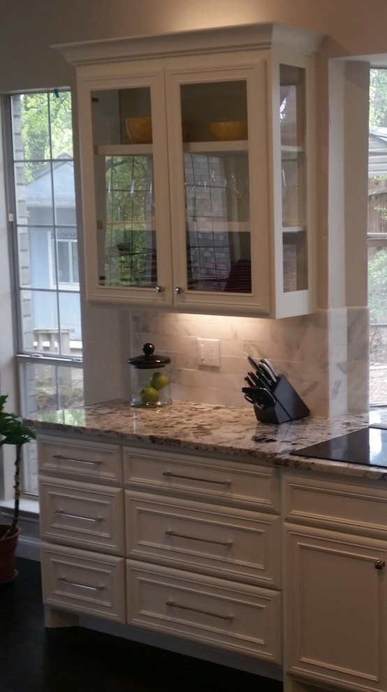 Mid-sized transitional dark wood floor and brown floor eat-in kitchen photo in Dallas with a farmhouse sink, shaker cabinets, white cabinets, granite countertops, gray backsplash, subway tile backsplash, stainless steel appliances and an island