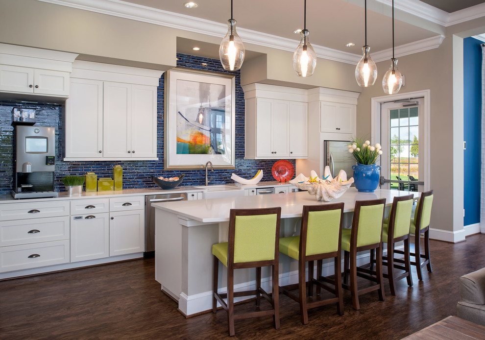 Inspiration for a beach style galley kitchen in New York with a farmhouse sink, shaker cabinets, white cabinets, blue splashback, stainless steel appliances, dark hardwood floors and with island.