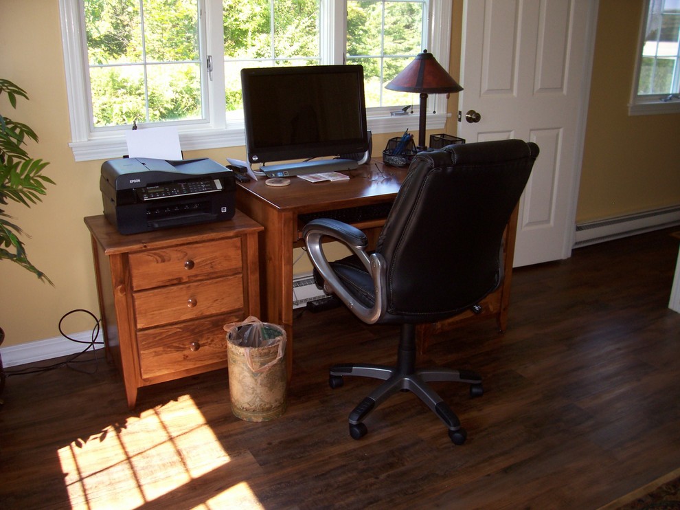 This is an example of a small country study room in Burlington with a freestanding desk, beige walls, medium hardwood floors, no fireplace and brown floor.