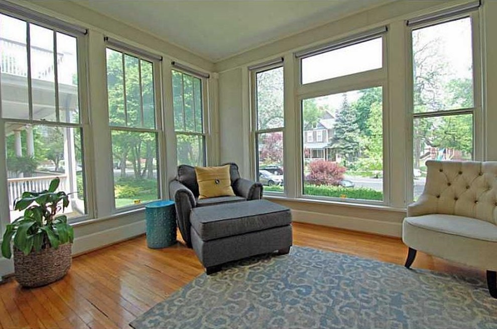 This is an example of a mid-sized transitional sunroom in Indianapolis with light hardwood floors and a standard ceiling.