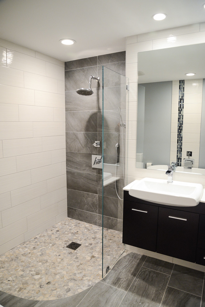 Inspiration for a small contemporary master bathroom in Raleigh with flat-panel cabinets, black cabinets, a curbless shower, a two-piece toilet, gray tile, white walls, a drop-in sink, engineered quartz benchtops and a hinged shower door.