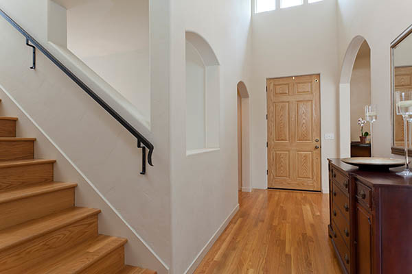 Example of a mid-sized transitional medium tone wood floor foyer design with white walls and a medium wood front door