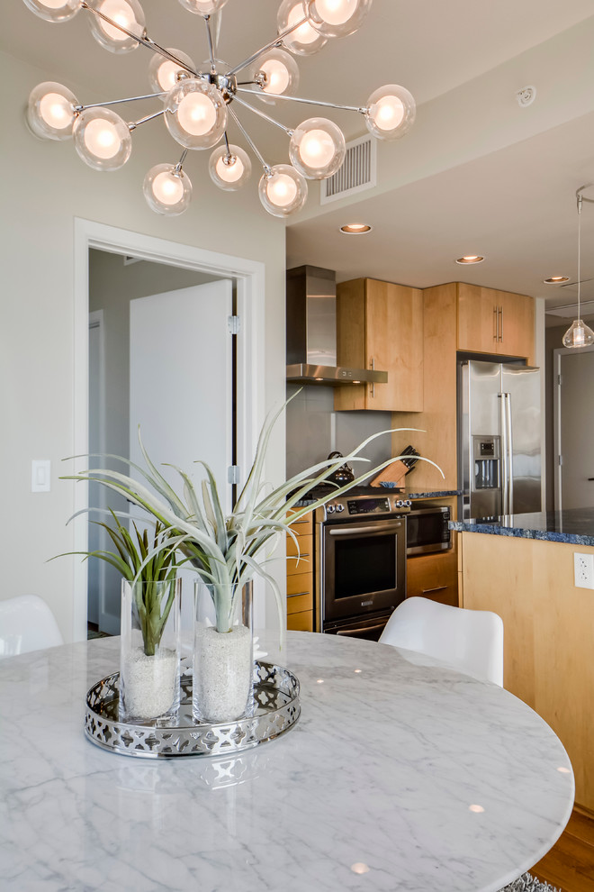Example of a small transitional galley light wood floor open concept kitchen design in Austin with a double-bowl sink, flat-panel cabinets, light wood cabinets, granite countertops, gray backsplash, porcelain backsplash, stainless steel appliances and an island