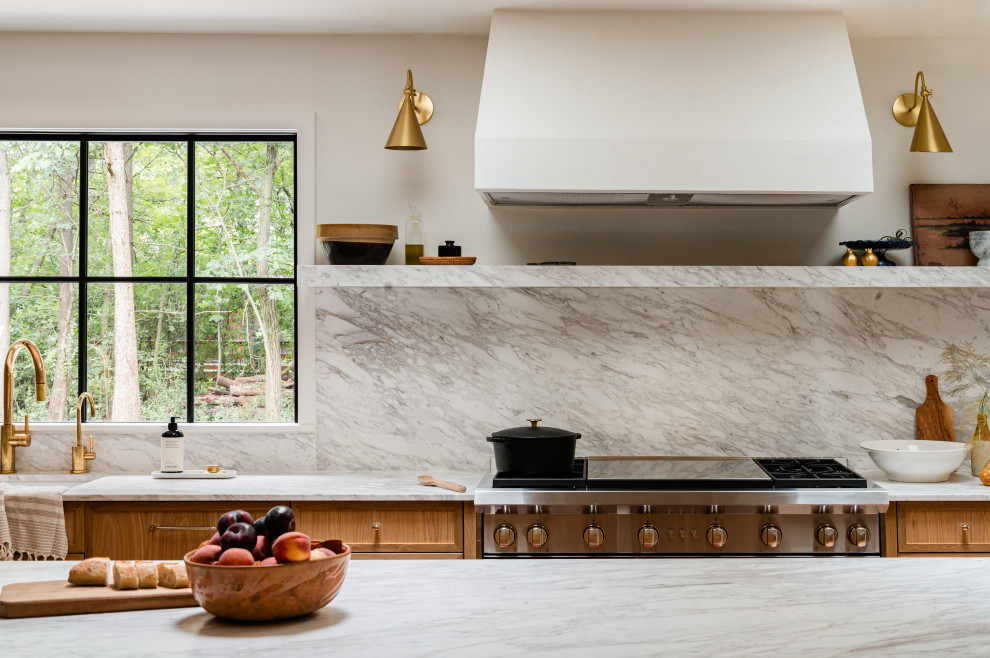 Example of a mid-sized transitional l-shaped light wood floor eat-in kitchen design in Chicago with an undermount sink, shaker cabinets, light wood cabinets, marble countertops, white backsplash, marble backsplash, paneled appliances, an island and white countertops