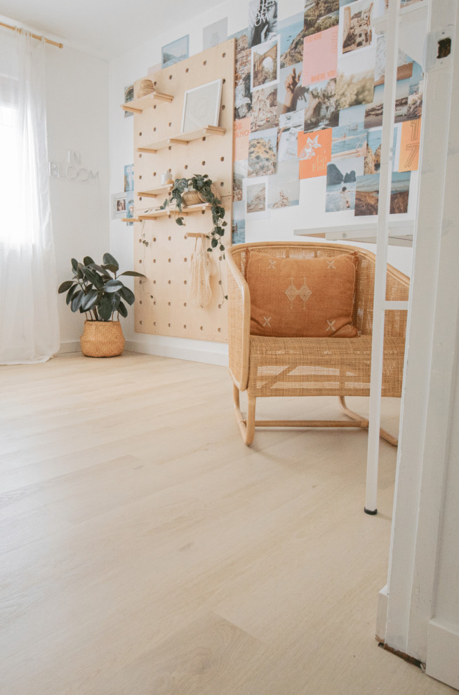 Photo of a mid-sized scandinavian craft room in Boise with white walls, vinyl floors, a freestanding desk and beige floor.