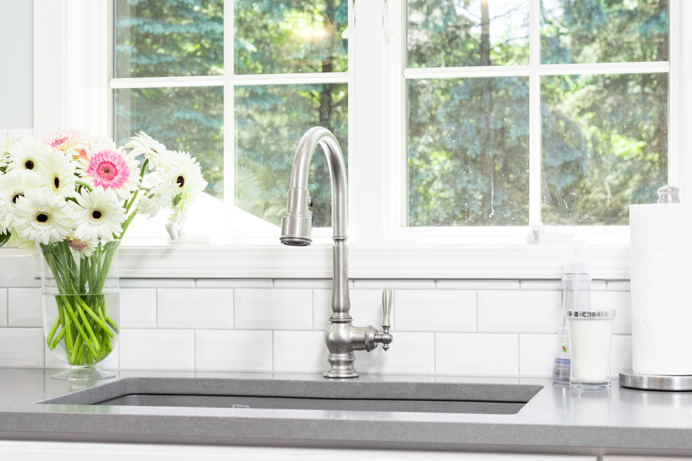 Eat-in kitchen - large transitional u-shaped medium tone wood floor and brown floor eat-in kitchen idea in Detroit with an undermount sink, raised-panel cabinets, white cabinets, quartz countertops, white backsplash, ceramic backsplash, an island and white appliances