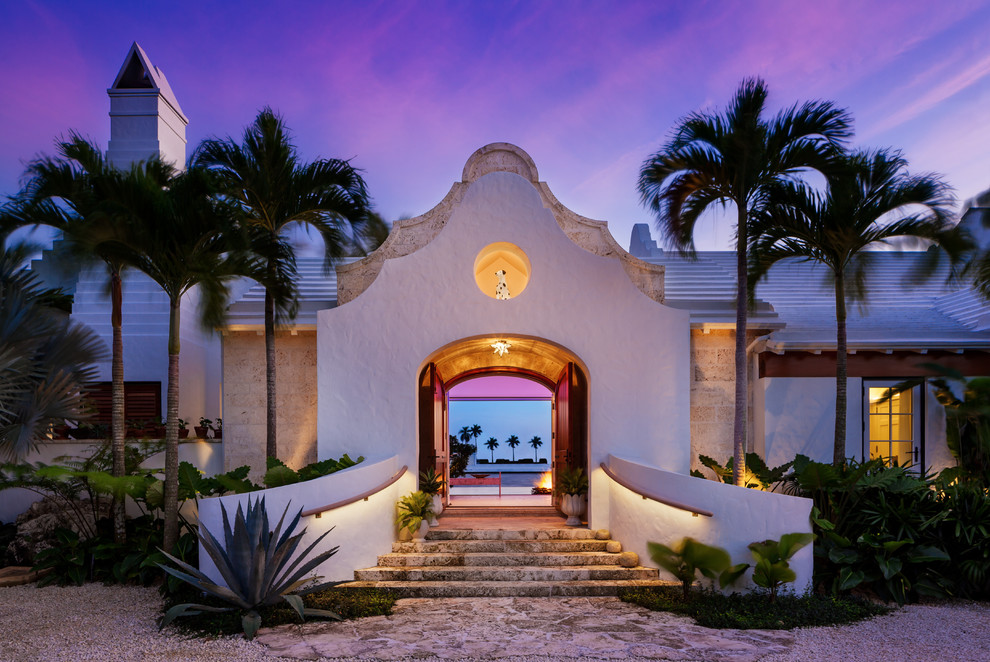 This is an example of a large modern two-storey stucco white house exterior in Miami with a gable roof and a tile roof.