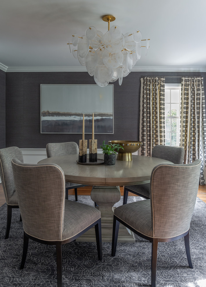 Transitional dining room in New York with medium hardwood floors, brown floor, wallpaper and grey walls.