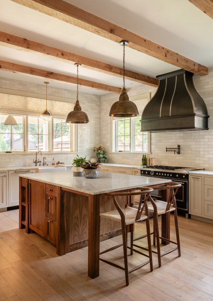 Ramsey House - Cottage l-shaped light wood floor, beige floor and exposed beam kitchen photo in Austin with a farmhouse sink, shaker cabinets, beige cabinets, white backsplash, subway tile backsplash, black appliances, an island and white countertops