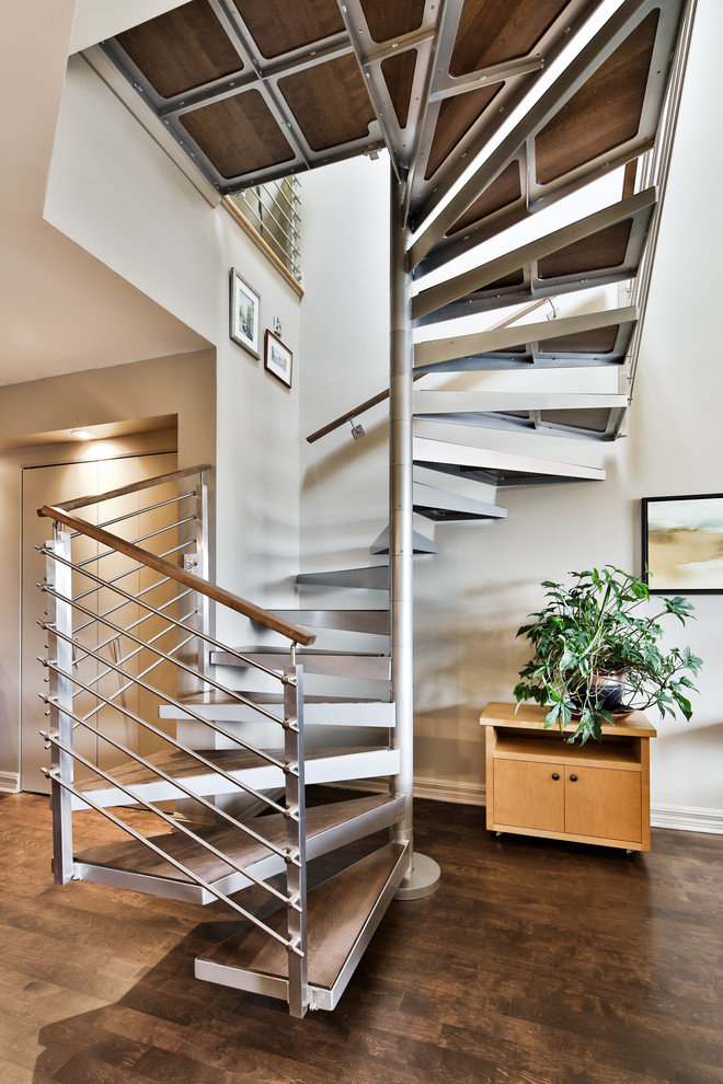 This is an example of a small contemporary wood spiral staircase in Montreal with open risers.