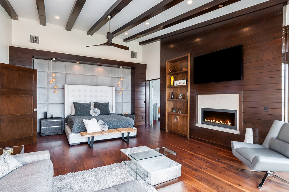 Photo of a contemporary master bedroom in Los Angeles with brown walls, dark hardwood floors, a standard fireplace and brown floor.